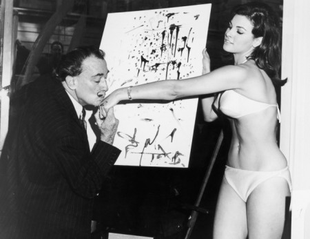 Сальвадор Дали целует руку актрисе Ракель Уэлч на фоне ее абстрактного портрета, 1965