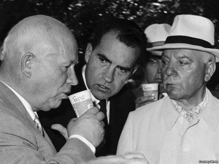 Никита Хрущев (слева) пьет пепси-колу, за ним наблюдает Ричард Никсон (в центре). Американская выставка в Москве, июль 1959 года